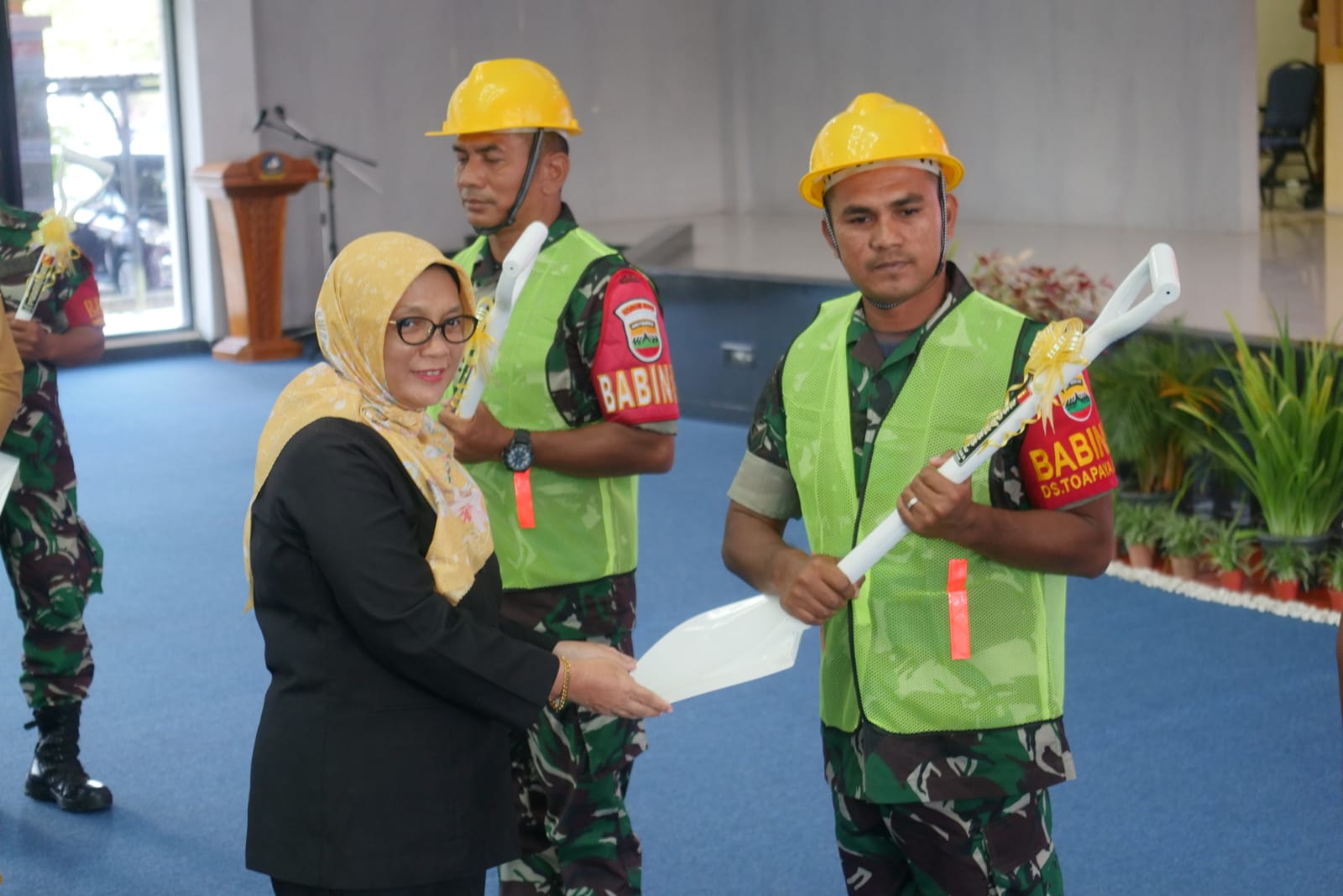 Anggota DPRD Bintan Fiven Sumanti menyerahkan skop ke Babinsa sebagai tanda dimulainya Program Karya Bhakti Pembangunan RTLH.